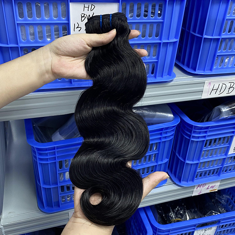 Scarlett Hair Black body wave hair extensions held in hand, showing texture and shine.